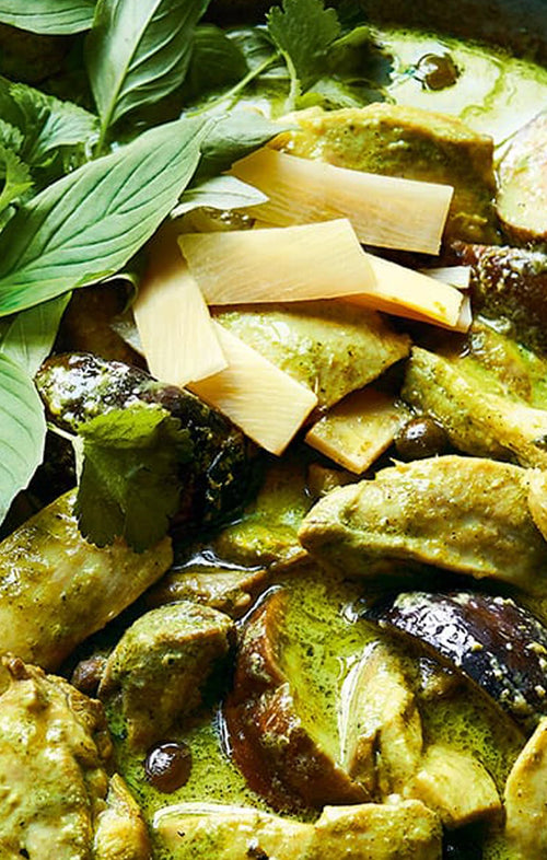 Green curry with eggplant and bamboo shoots on a bed of basil leaves