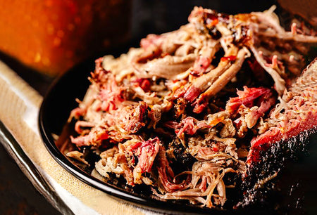 Shredded meat on a black plate with a close-up view