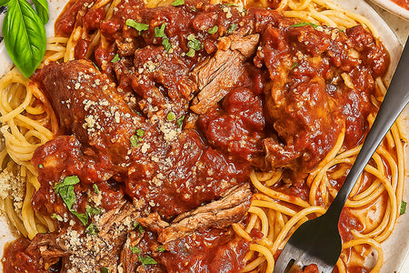 Spaghetti with meat sauce on a plate with a fork