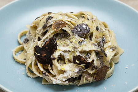 Pasta dish with truffles on a blue plate