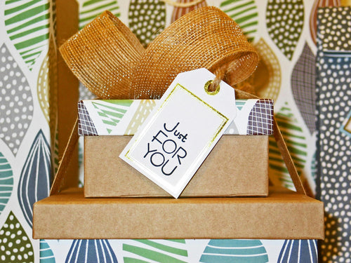 Gift box with a brown ribbon and 'Just For You' tag on a patterned background